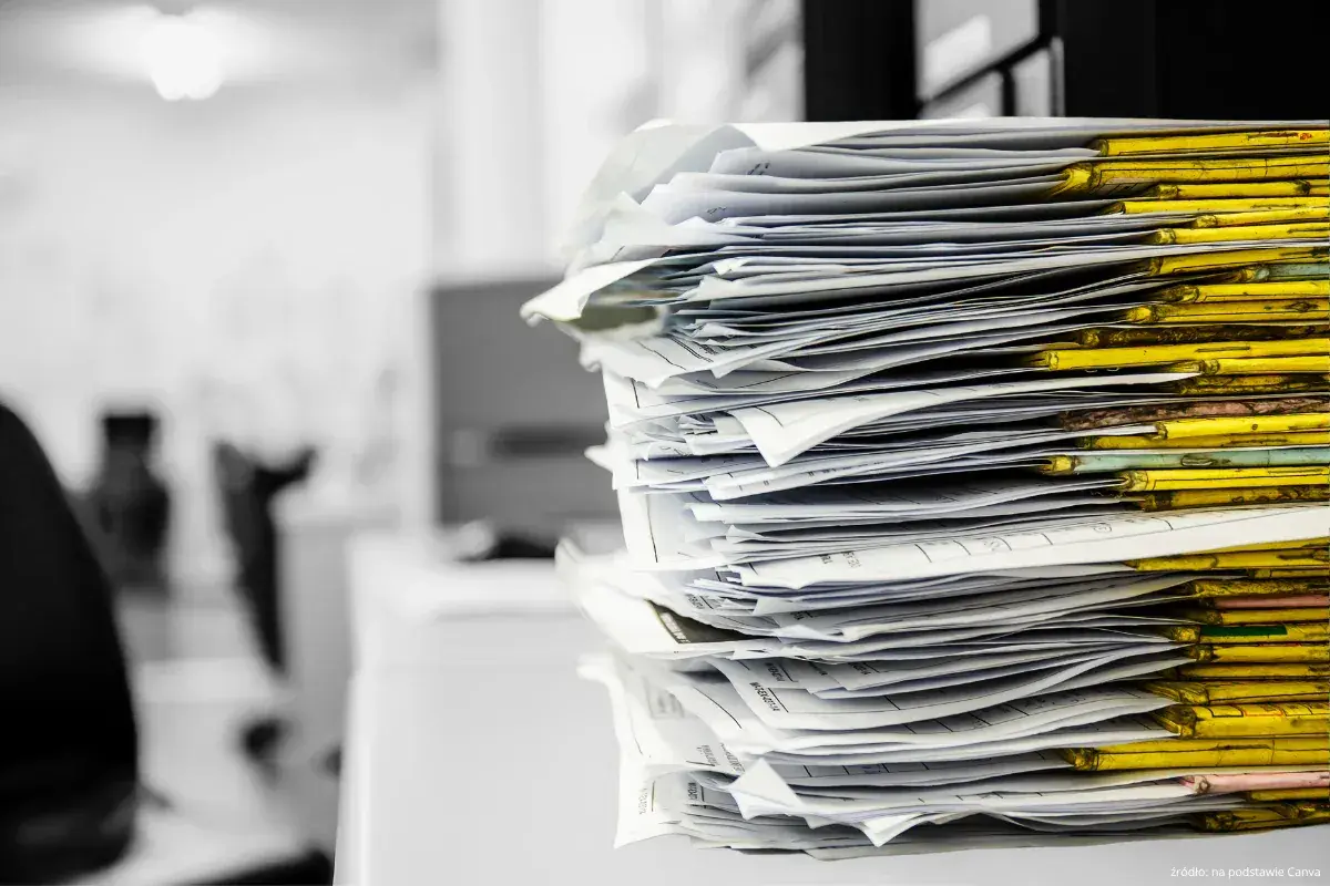 Stos papierów w żółtych segregatorach. Czas na porządki, co to znaczy? Niezwłocznie!