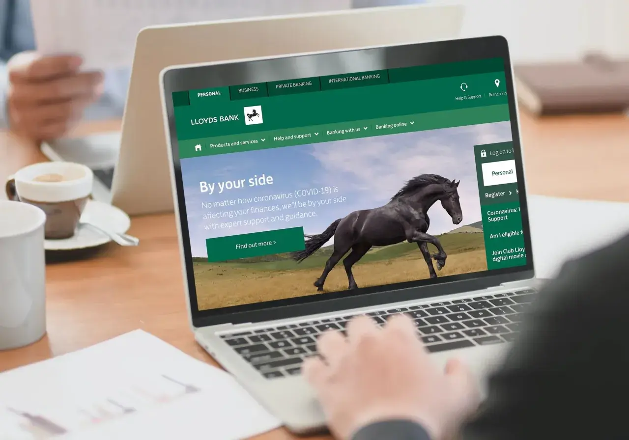Strona internetowa Lloyds Bank z hasłem "By your side" i czarnym koniem. Dostępne opcje: Personal, Business, Private Banking.