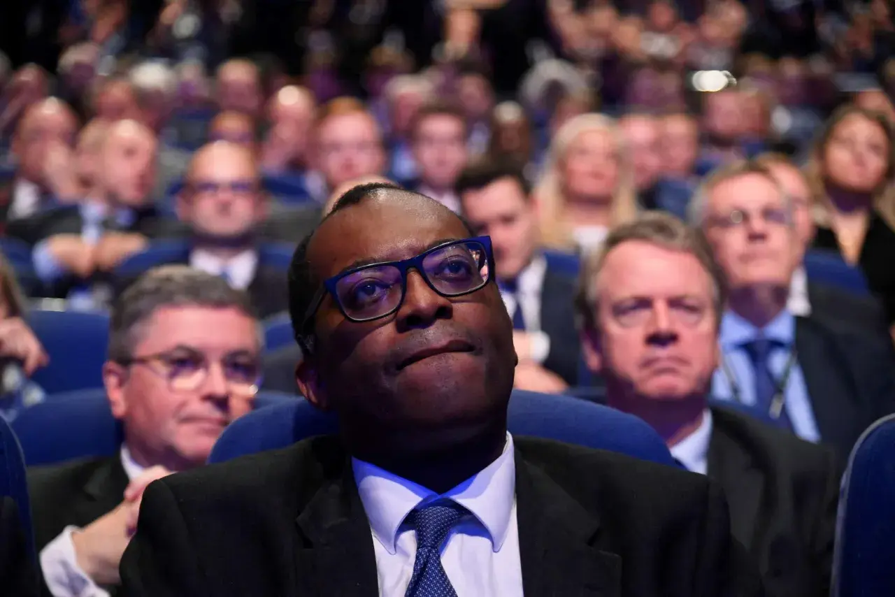 A man in glasses looks up, surrounded by a blurred audience. This scene captures a moment of collective attention, hinting at the shared experience and what is social impact.