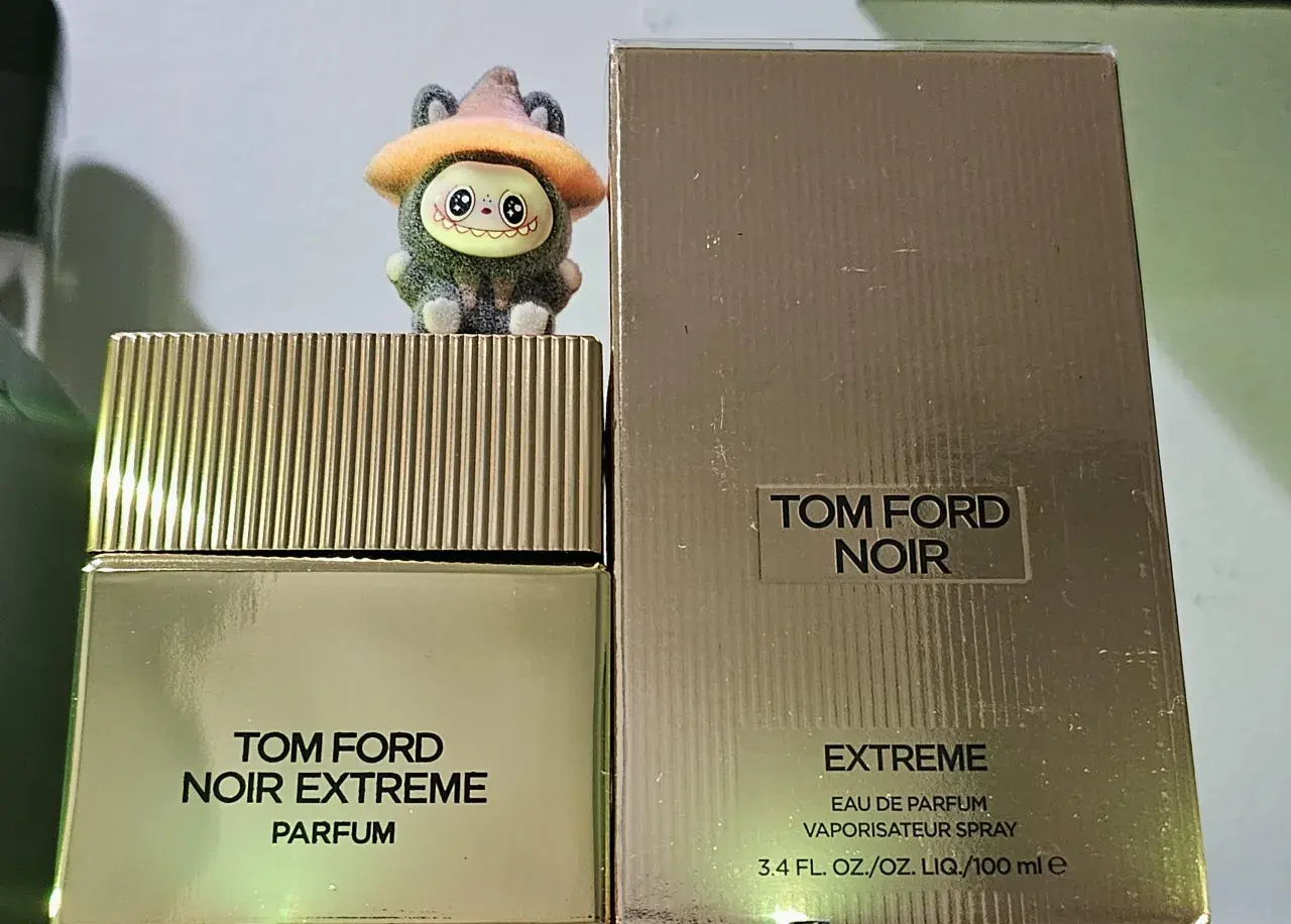 Urocza figurka na flakonie Tom Ford Noir Extreme Parfum. Złote opakowanie i korek dodają elegancji.