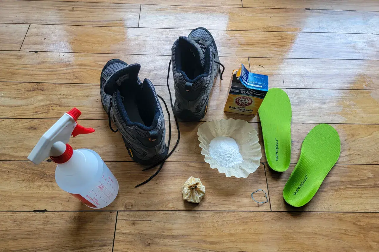 Gather supplies to learn how to clean hiking boots: boots, spray bottle, baking soda, coffee filter, and insoles.