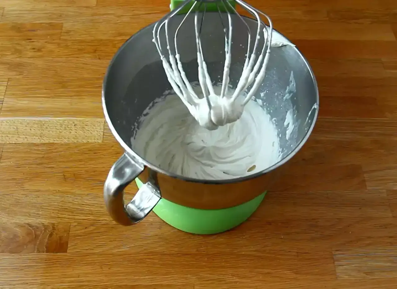 Mieszadło miksera zanurzone w puszystej masie z mascarpone, gotowej do dalszych deserowych przygód.
