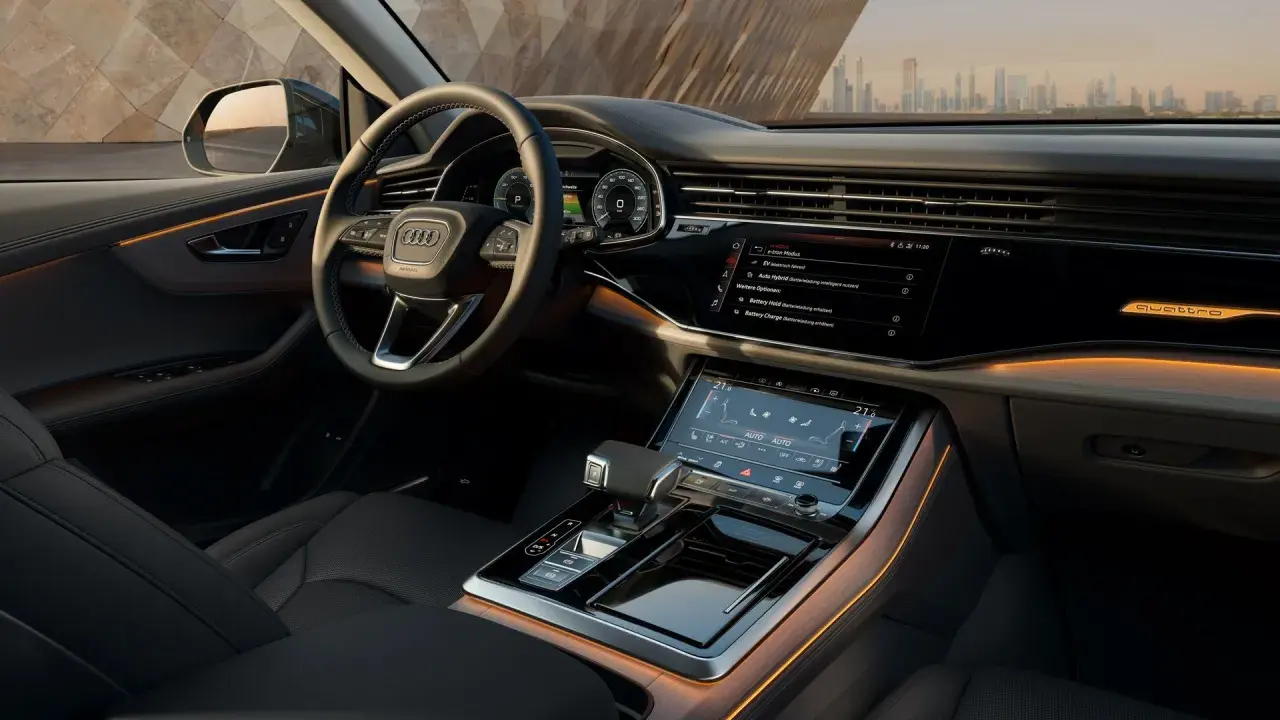 Interni lussuosi dell'Audi Q8 con illuminazione ambientale e schermi digitali.