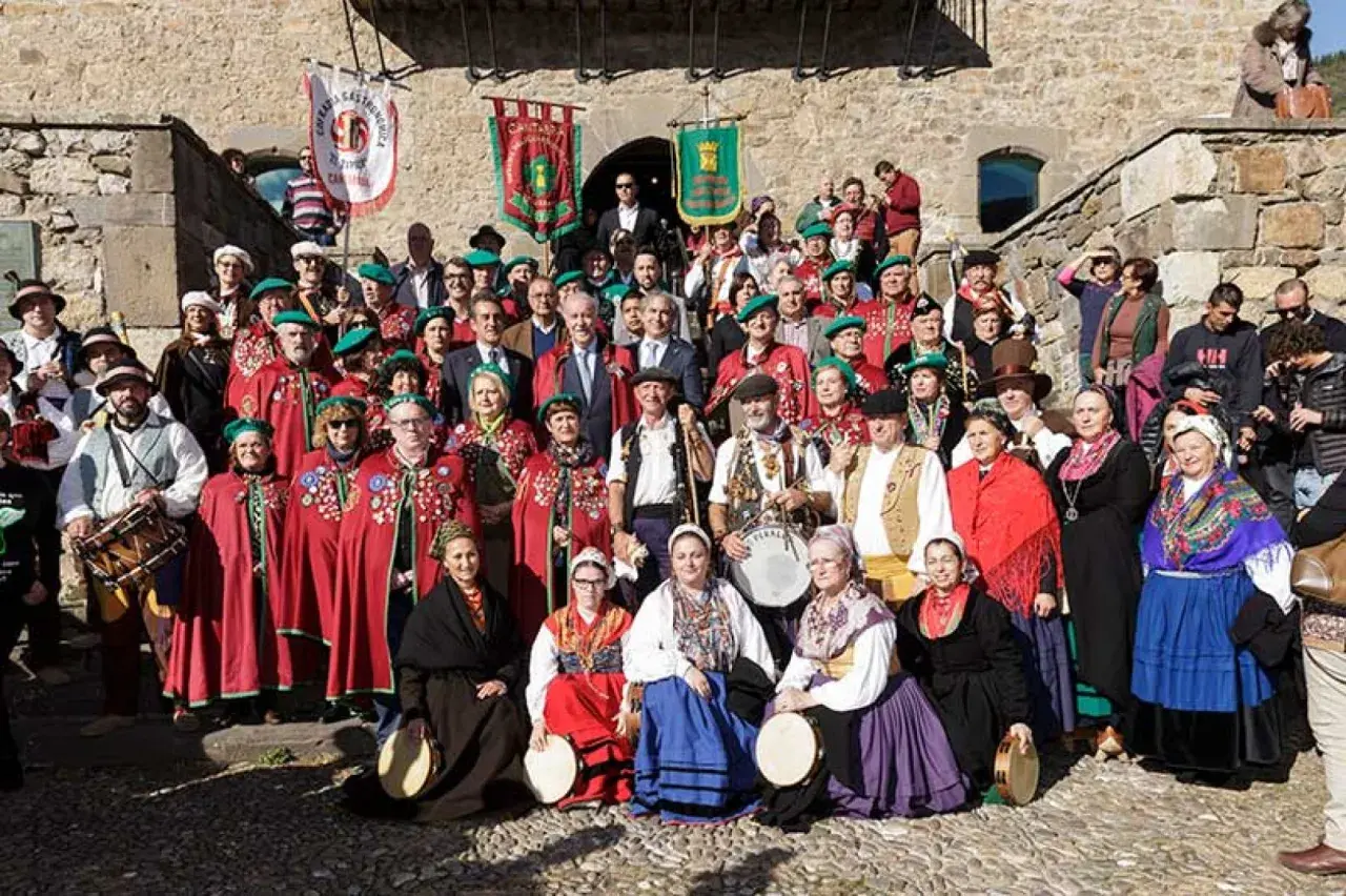 Grupo posa con trajes tradicionales en la fiesta del orujo Potes, algunos portan tambores y panderetas.