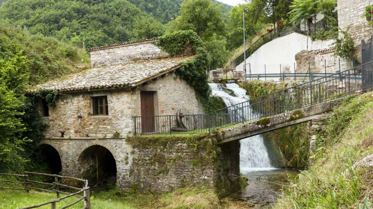 Antico mulino in pietra con cascata e ponte a Pieve Torina. Un luogo suggestivo da scoprire, tra natura e storia.