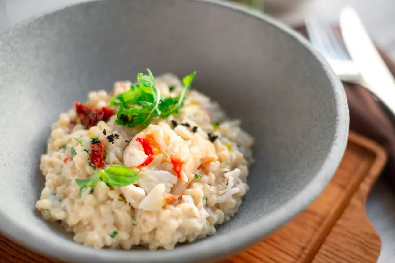 Un crémeux risotto aux fruits de mer, garni de basilic frais et de tomates séchées. Une recette de pâtes qui invite au voyage.