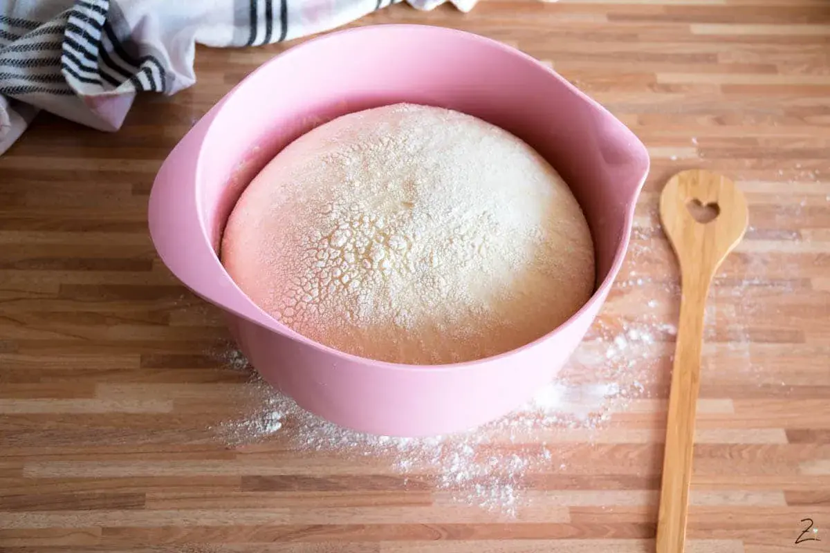 Hefeteig abends vorbereiten und morgens backen: Ein aufgegangener Teig in einer rosa Schüssel, bereit für den nächsten Tag.