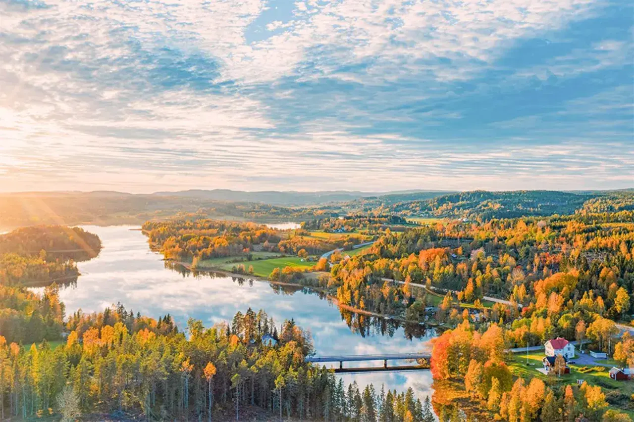 Herbstliche Landschaft in Schweden mit einem See, bunten Wäldern und einer Brücke. Ein Ort, den man gesehen haben muss!