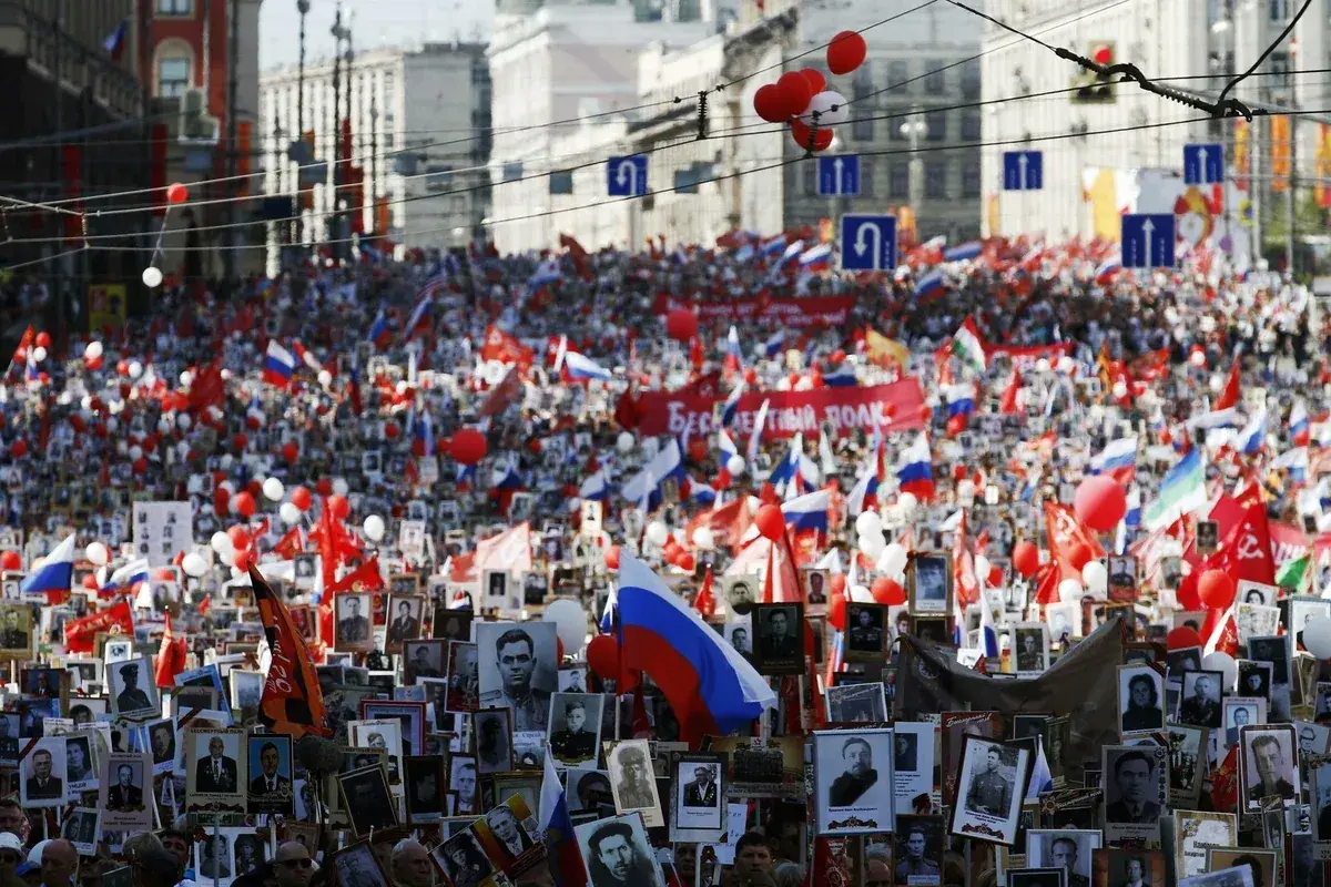 Großer Menschenauflauf mit Fotos und Fahnen in Russland am 8. Mai Feiertag.