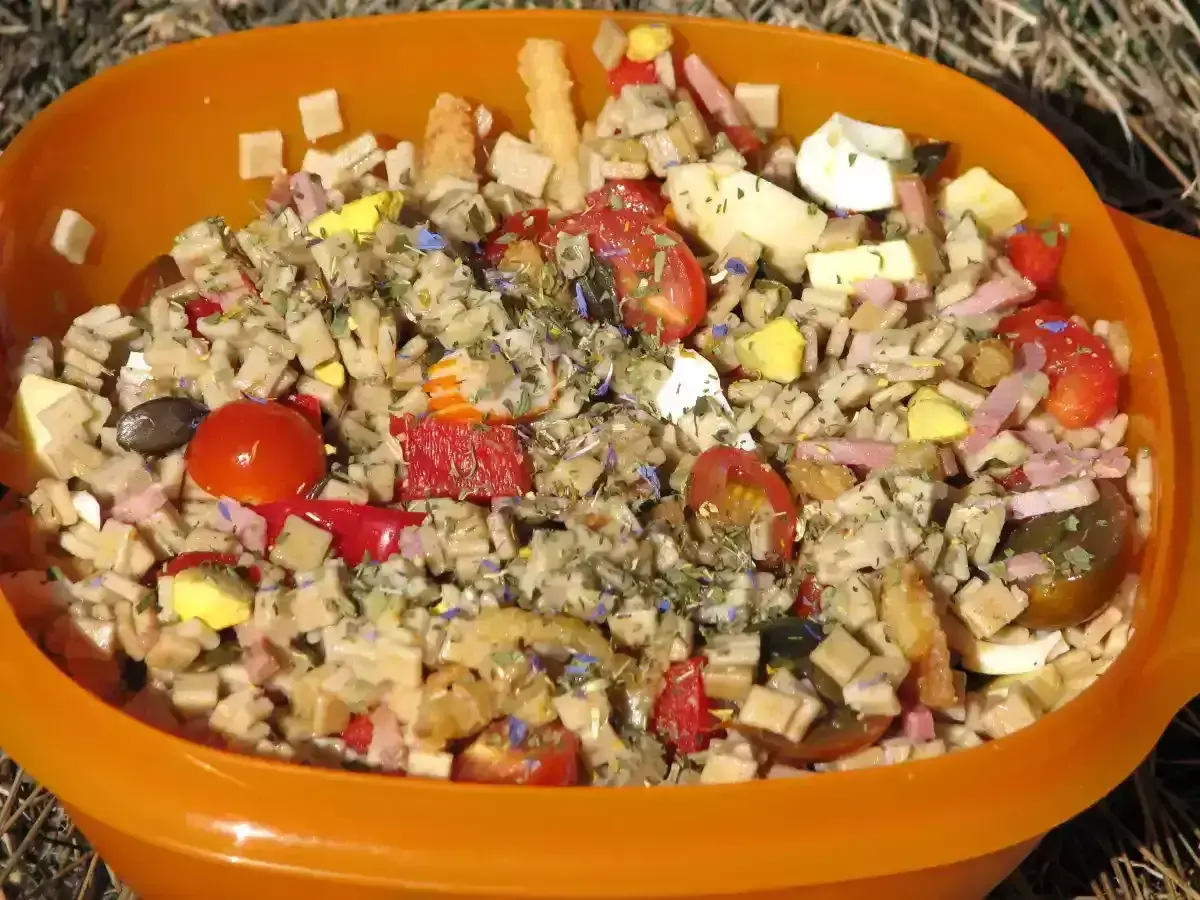 Salade de crozets au thon, garnie de tomates cerises, œufs durs, jambon et herbes. Un plat coloré et savoureux.