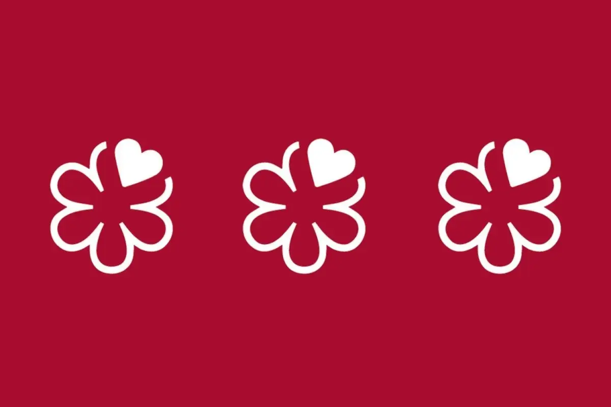 Tres flores blancas con un corazón en cada una, sobre fondo rojo. Símbolo de excelencia culinaria, como en restaurantes con 4 estrellas Michelin.