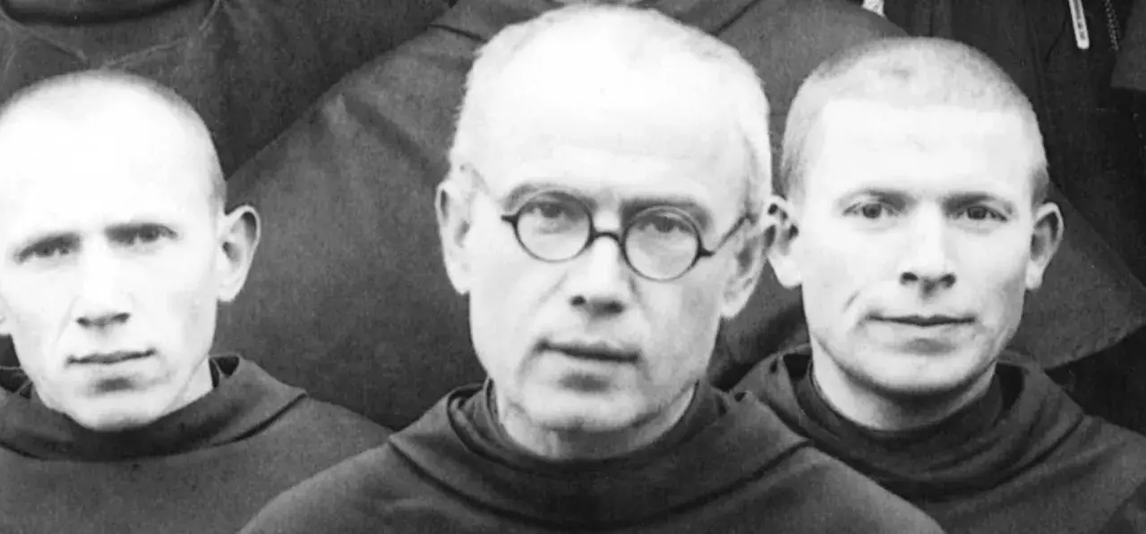 Trzej zakonnicy w habitach. W środku Maksymilian Kolbe w okularach. Ciekawostki o jego życiu i heroizmie.