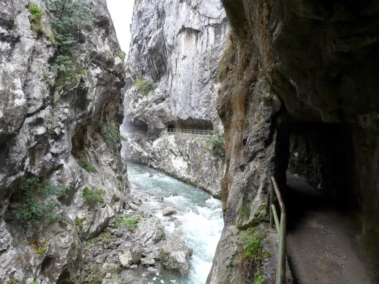 Sendero tallado en roca junto a un río caudaloso, parte de la ruta cain.