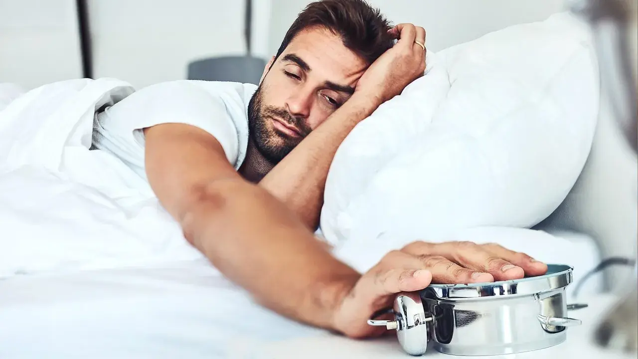 Man struggling to wake up, embodying the dysania meaning of difficulty getting out of bed.