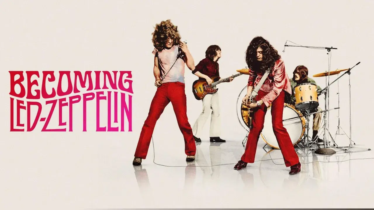 Zespół Led Zeppelin w akcji. Wokalista z mikrofonem, gitarzysta, basista i perkusista tworzą potężne brzmienie.
