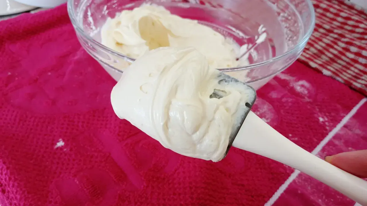 Crème onctueuse de mascarpone sur une spatule, prête pour une délicieuse recette.