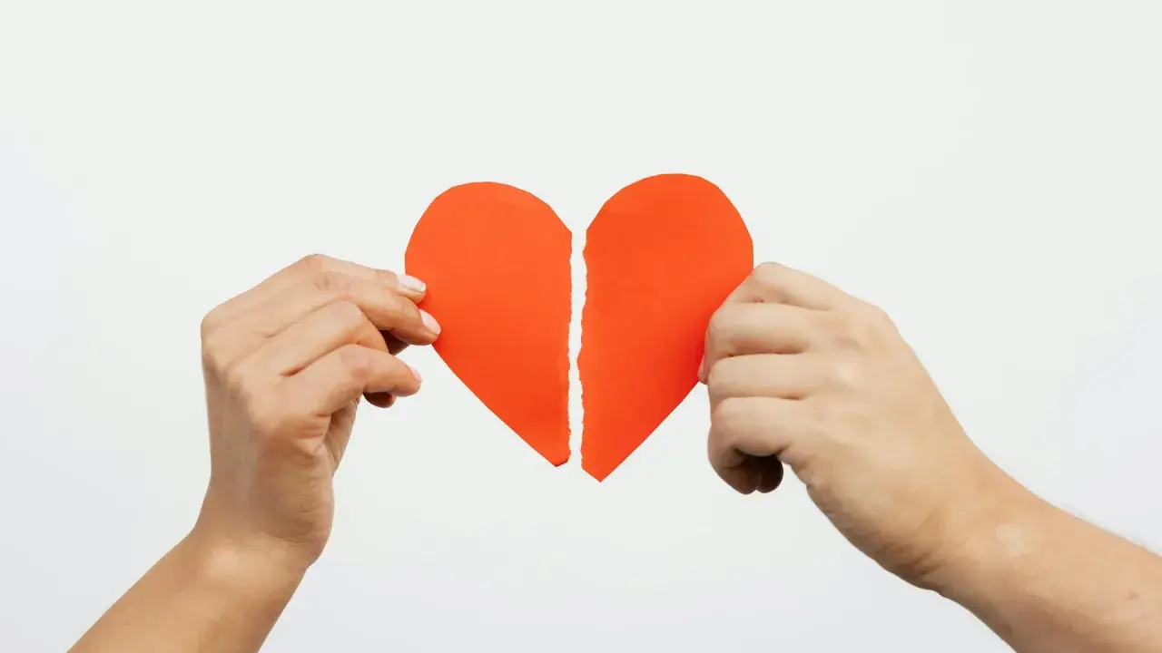 Mani che tengono un cuore rosso spezzato. Ho perdonato un tradimento ma non riesco a dimenticare.