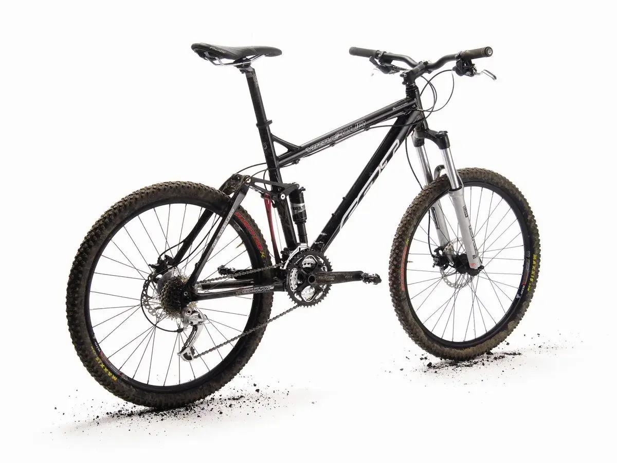 A black full-suspension mountain bike, the "Felt Virtue," stands ready for adventure. Its knobby tires are dusted with dirt, hinting at recent trails.