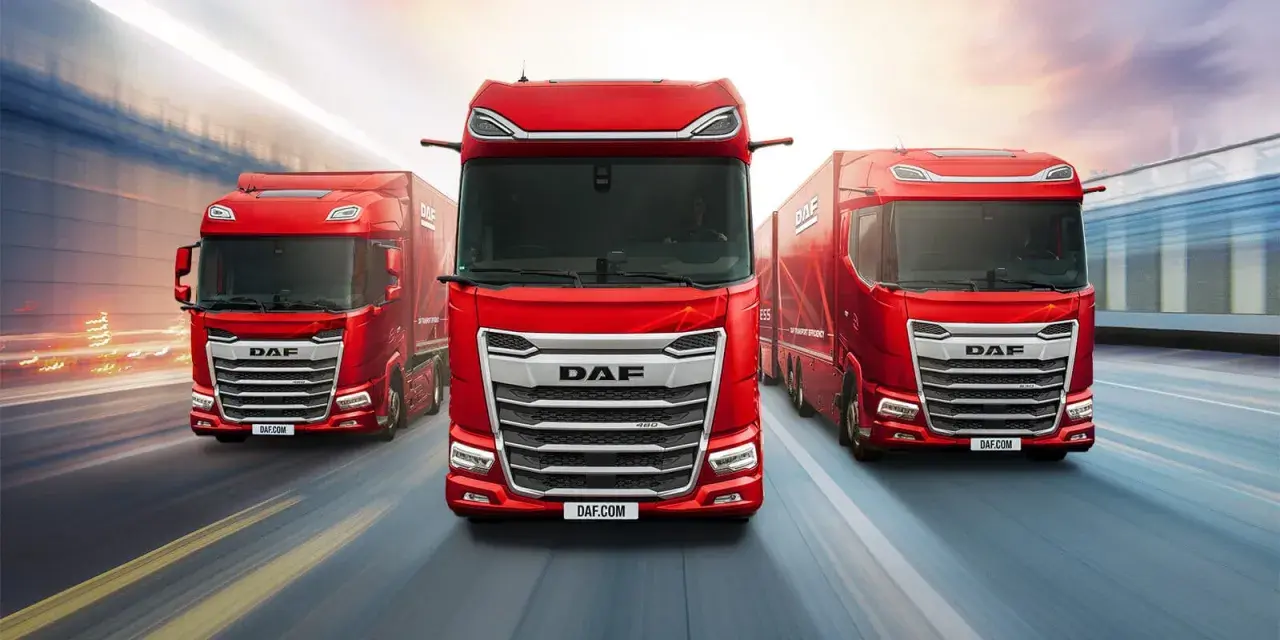 Trois camions DAF rouges sur une route floue. L'intérieur du DAF XF est visible, avec un conducteur au volant.