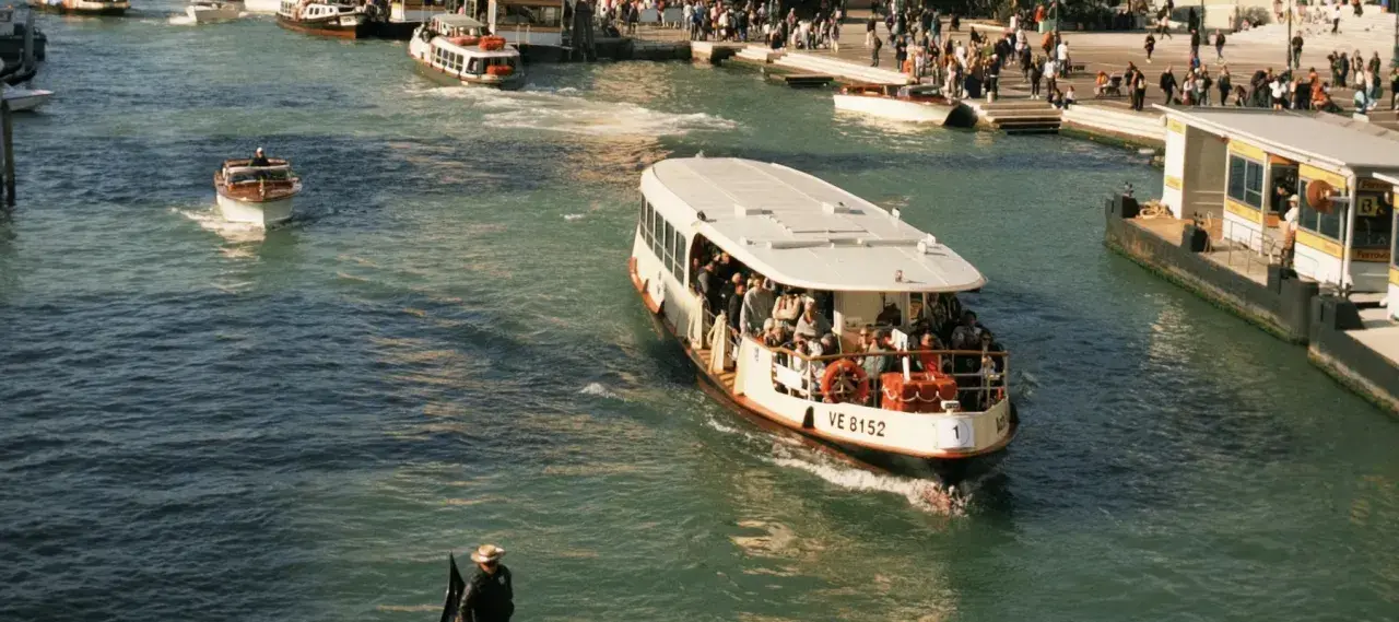 Ein belebter Vaporetto in Venedig transportiert Passagiere über das glitzernde Wasser.
