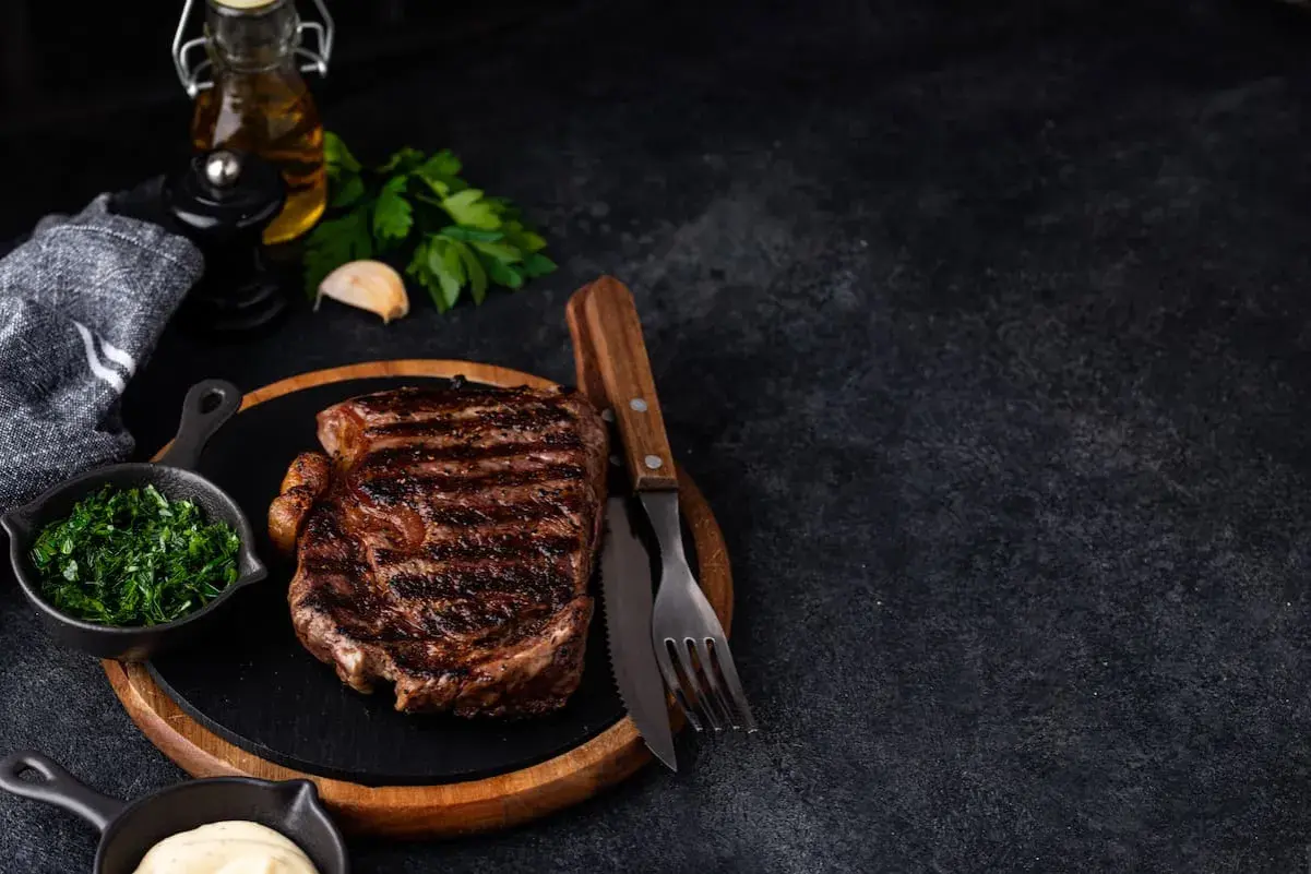 Un savoureux steak black angus grillé, servi avec des herbes fraîches et une sauce crémeuse. Un délice pour les amateurs de viande.