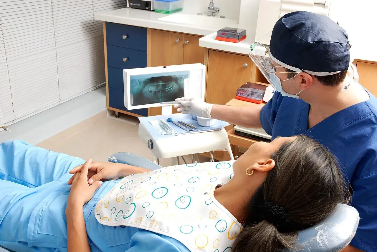 Dentysta omawia z pacjentką zdjęcie RTG, szukając rozwiązań co zamiast leczenia kanałowego.