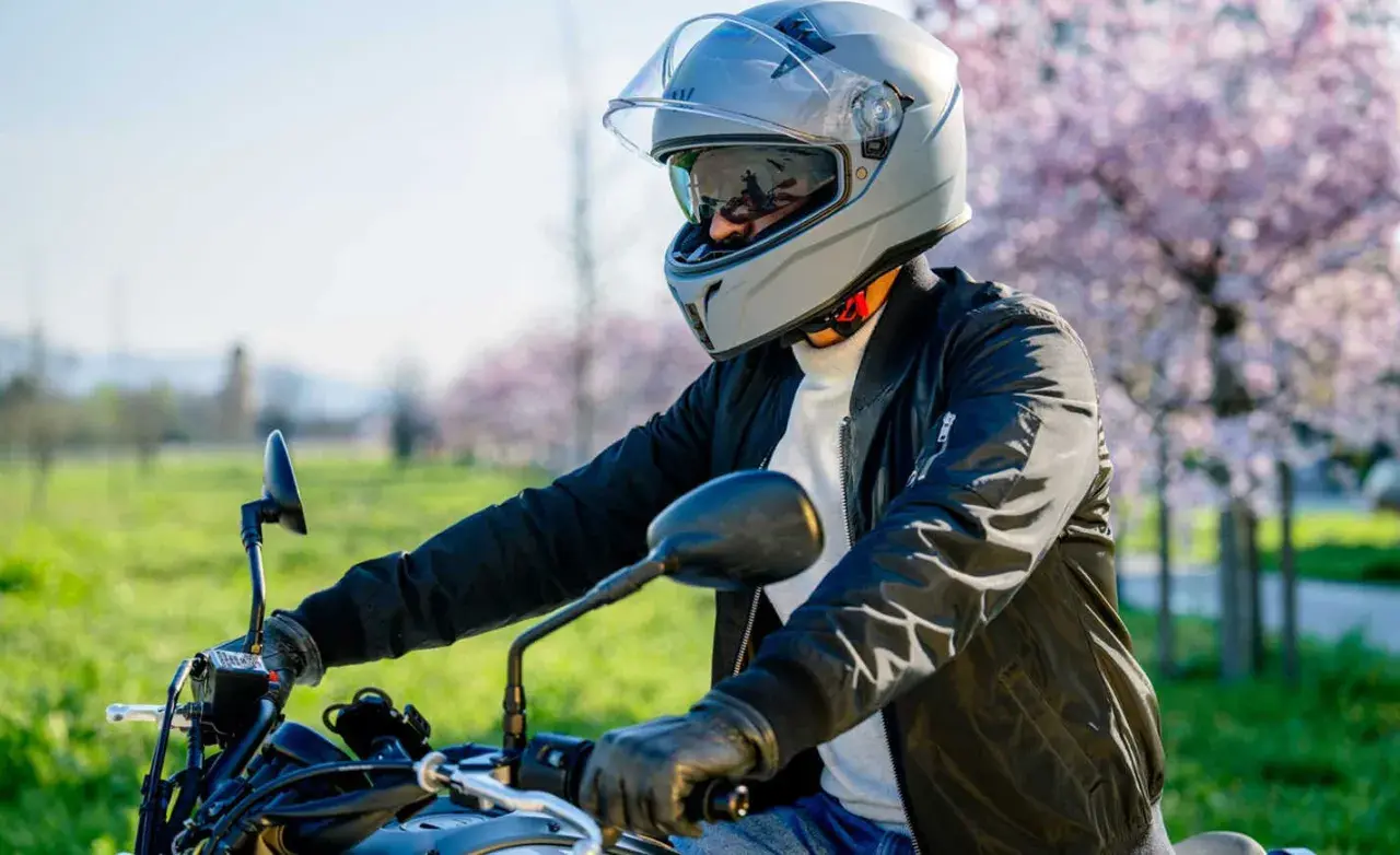 Motociclista con casco grigio, pronto per un giro. La scelta del giusto **misura casco moto** è fondamentale per la sicurezza.