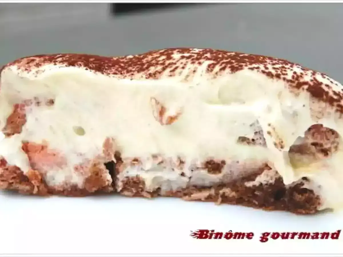 Tranche de tiramisu crémeux, parsemé de cacao, avec des morceaux de biscuit rose. Un délice !
