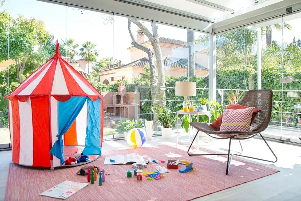 Tienda de circo y juguetes para disfrutar de juegos de patio en un espacio acristalado con vistas al jardín.