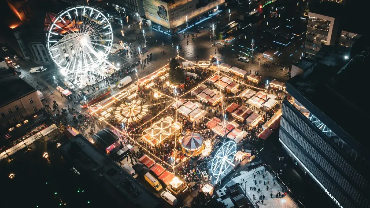 Nocny jarmark bożonarodzeniowy Katowice: rozświetlone stoiska, karuzela, diabelski młyn i lodowisko tworzą magiczną atmosferę.