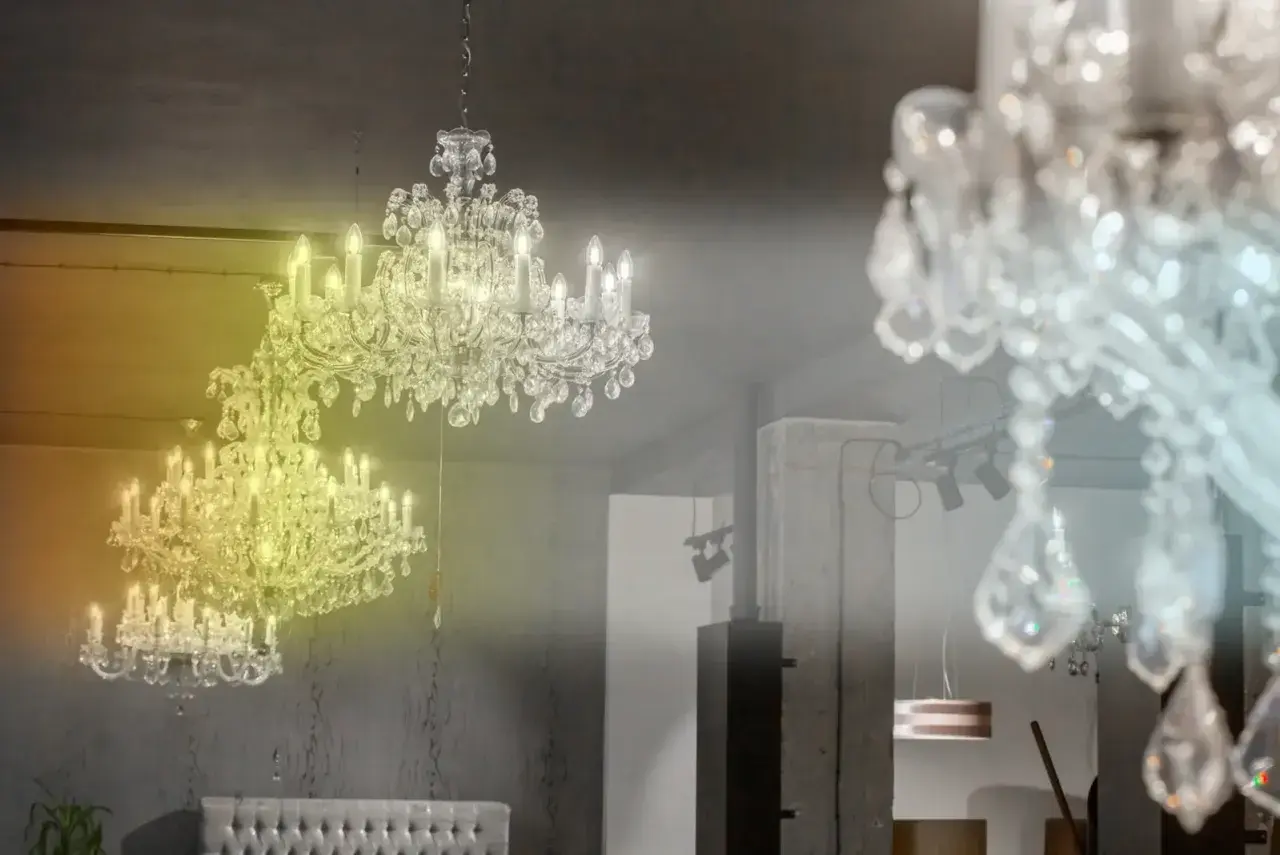 Lámpara techo cristal colores, dos candelabros de cristal brillan con luz cálida y fría, creando un ambiente elegante.