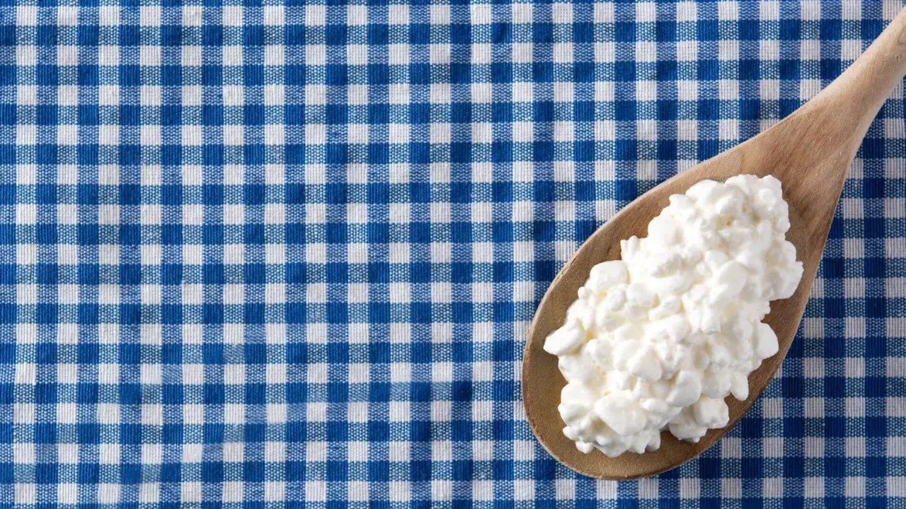 Un cucchiaio di jocca in gravidanza su una tovaglia a quadri blu e bianchi.