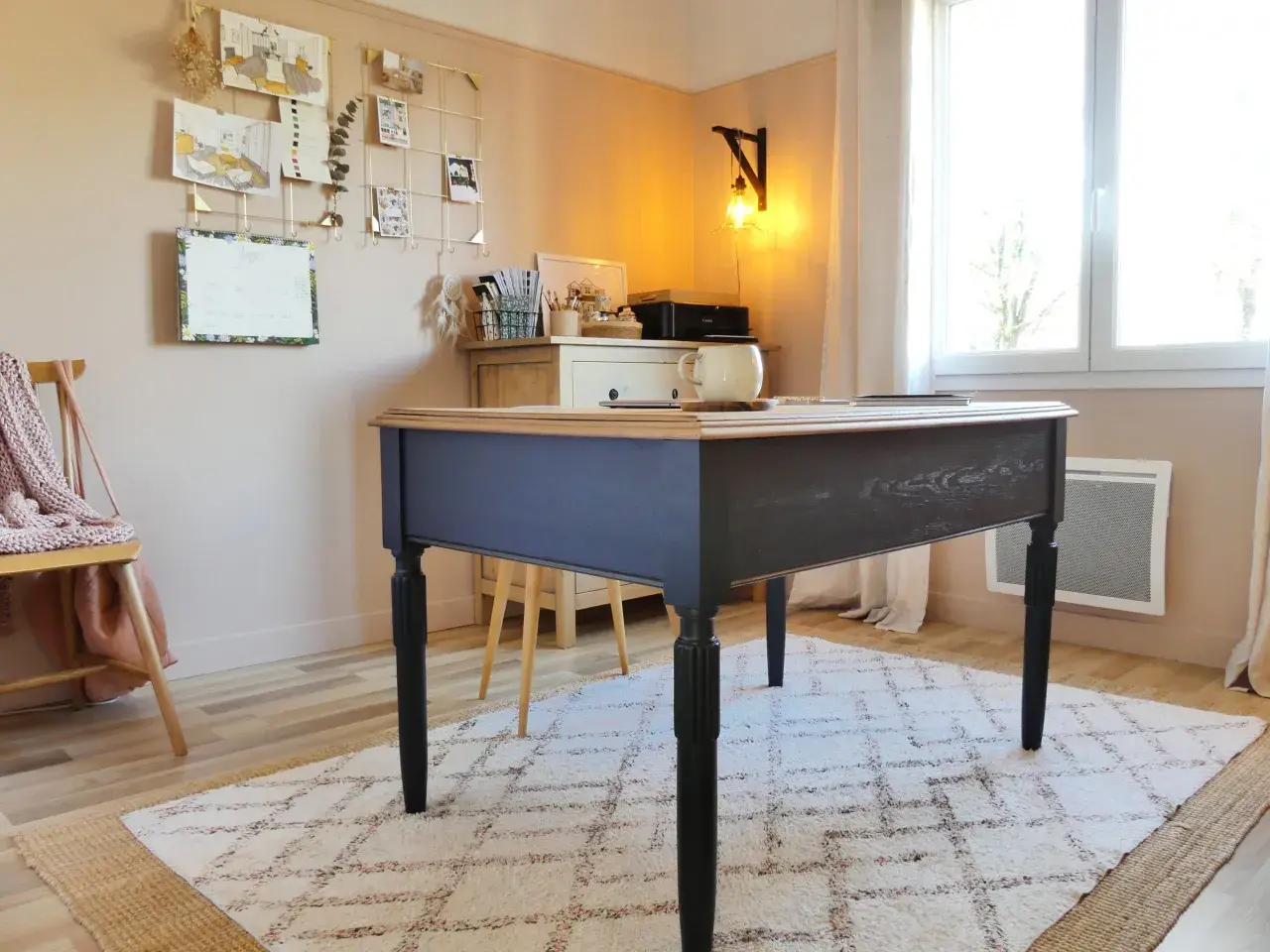 Bureau en bois peint en bleu marine, avec un plateau en bois naturel. Une tasse est posée sur le bureau.