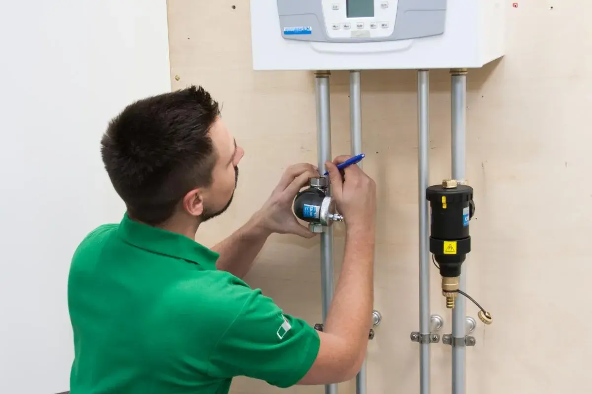 Instalator sprawdza, gdzie zamontować separator zanieczyszczeń przy kotle.