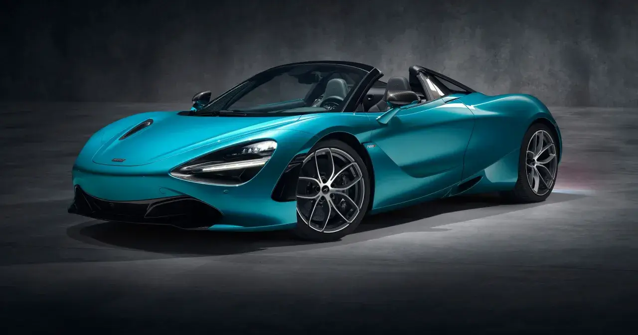 Turkusowy McLaren 720S Spider z otwartym dachem, gotowy do jazdy po torze.