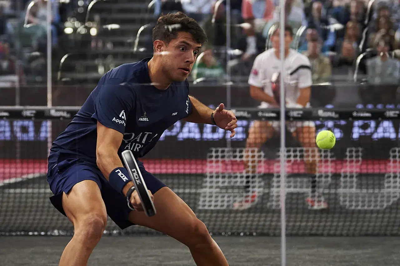 Agustin Tapia, con la sua agilità e altezza, colpisce la palla da padel in una partita intensa.