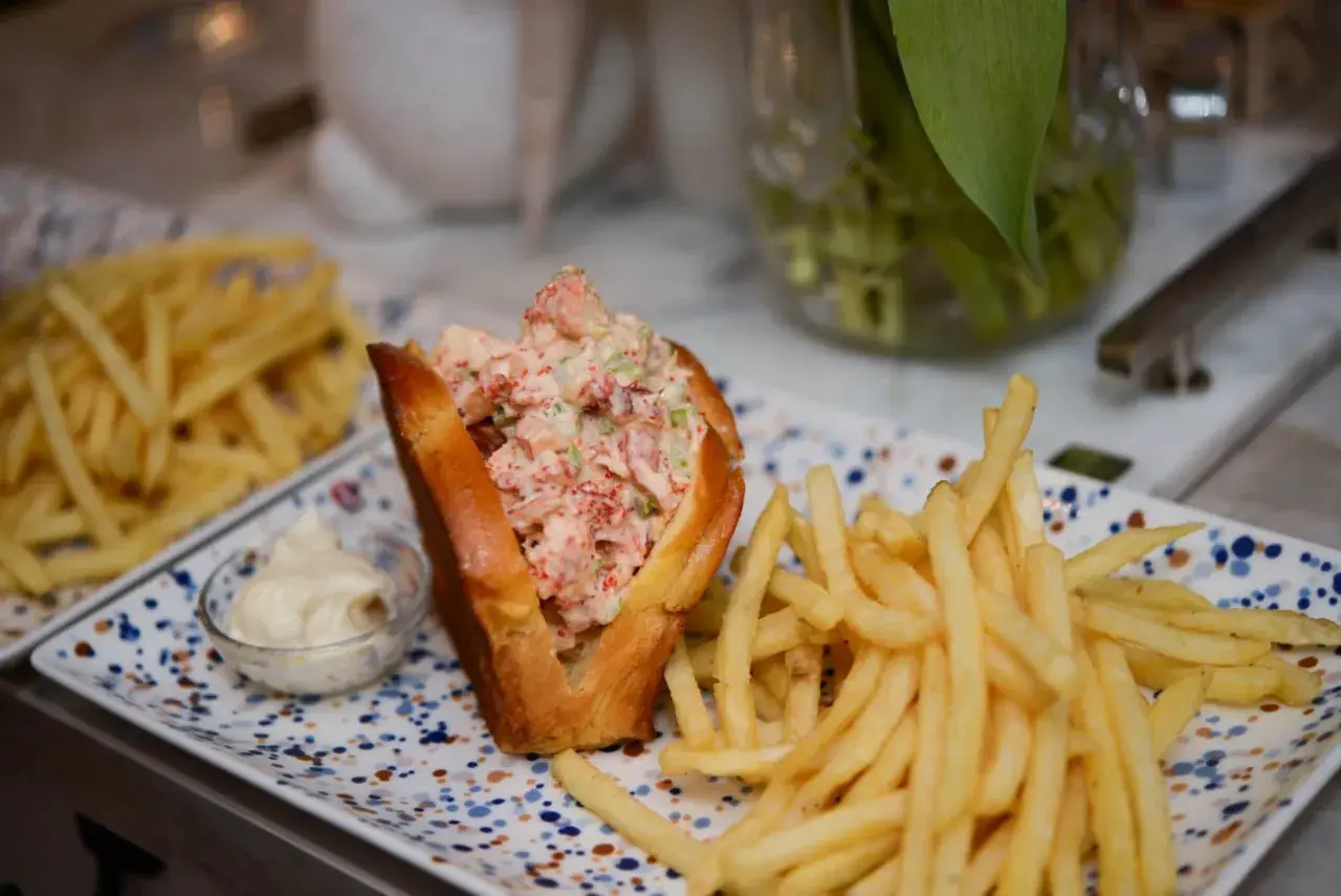 En saftig lobster roll med pommes frites och en liten skål majonnäs. En perfekt lunch!