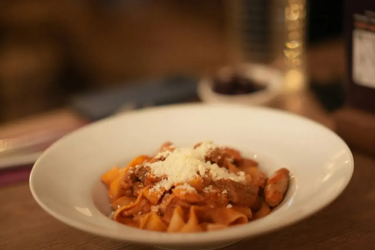 Pappardelle z sosem bolognese, posypane parmezanem. Pyszne danie, które może być inspiracją do przygotowania spaghetti bolognese przepis oryginalny.