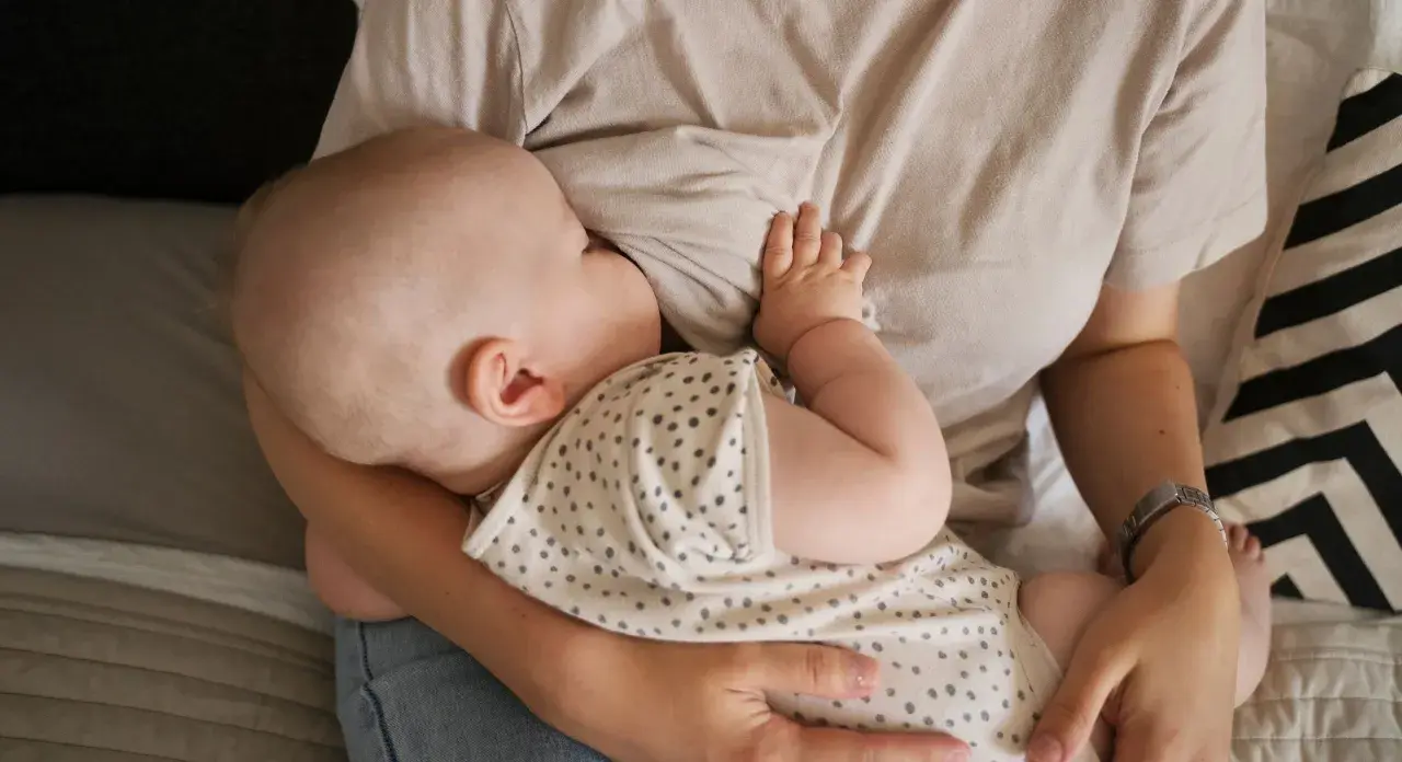 En bebis ammar. En mamma håller sitt barn nära. Dagen efter piller amning kan kännas annorlunda, men lugnet i stunden är detsamma.