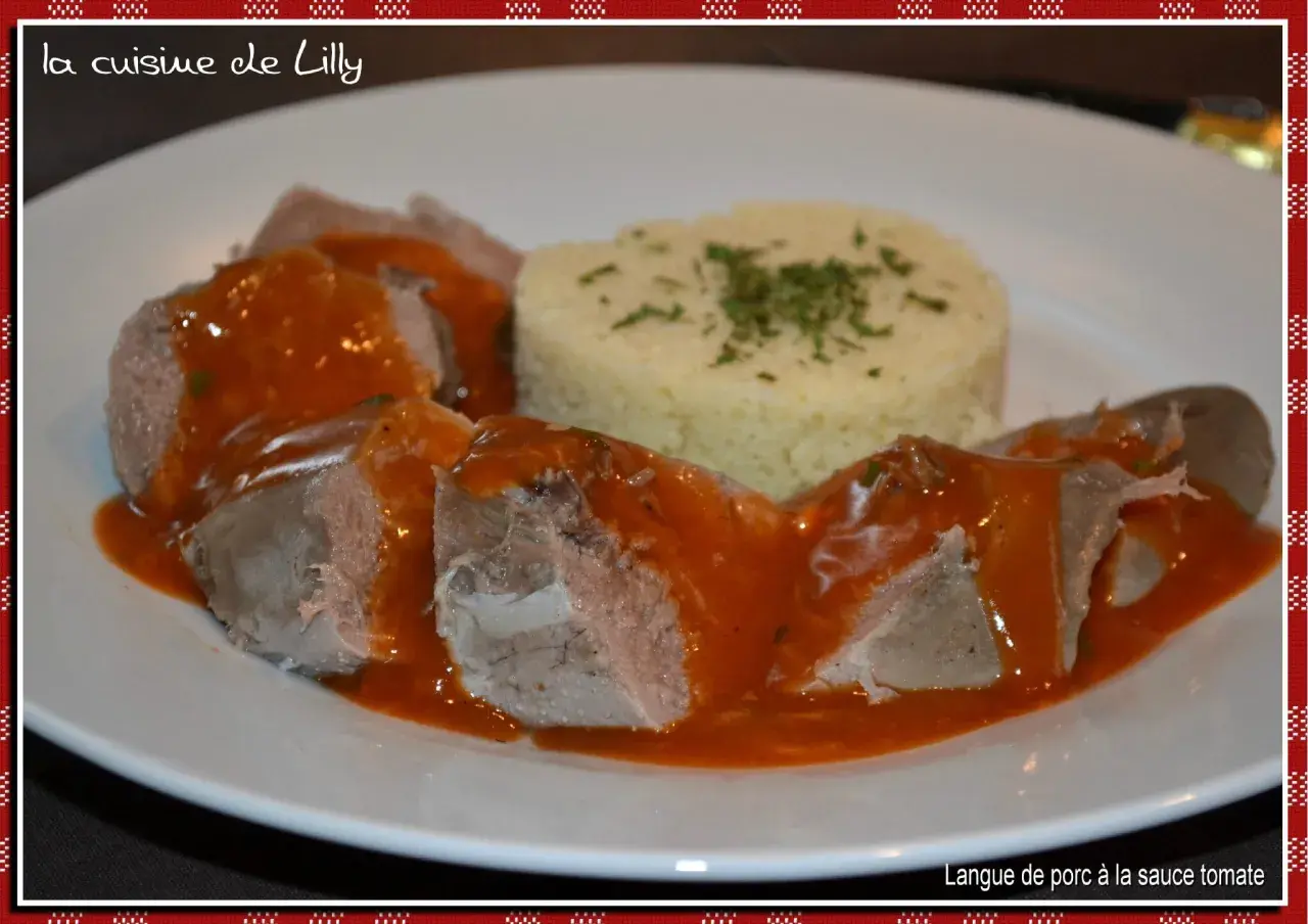 Langue de porc en sauce tomate, servie avec une portion de semoule garnie d'herbes. Un plat savoureux de "la cuisine de Lilly".