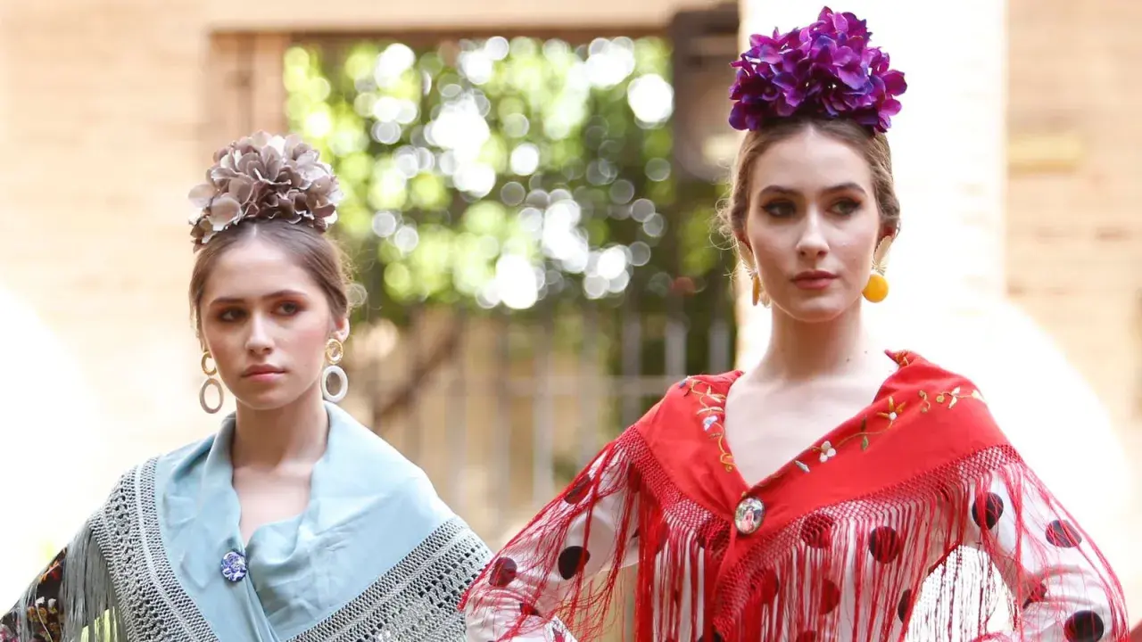 Dos jóvenes con maquillaje flamenca, flores en el pelo y mantones de seda.