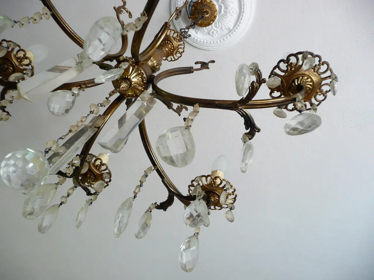 Dettagli di un lampadario a gocce in ottone con cristalli trasparenti. Un'idea su come rimodernare un lampadario a gocce con un tocco di eleganza.