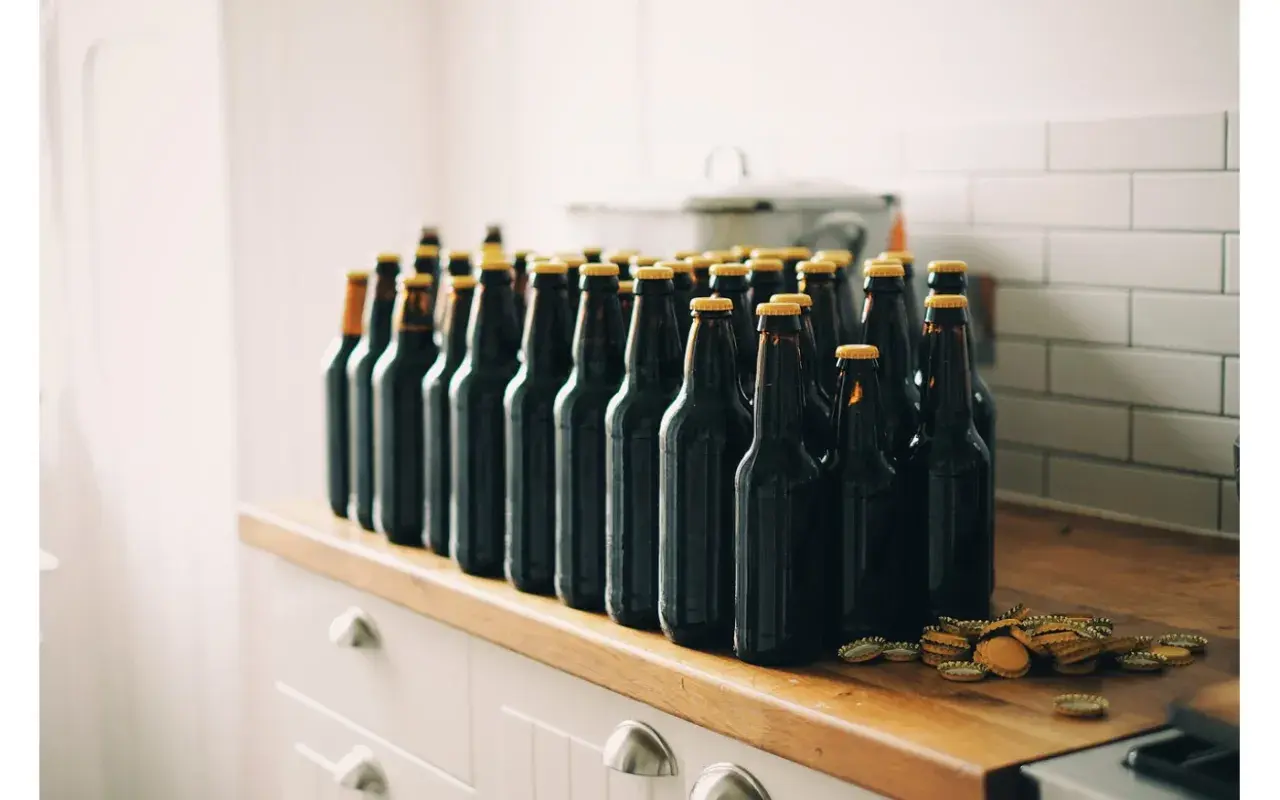 Rząd ciemnych butelek piwa, gotowych do degustacji. Zestaw brewkit Coopers czeka na otwarcie.