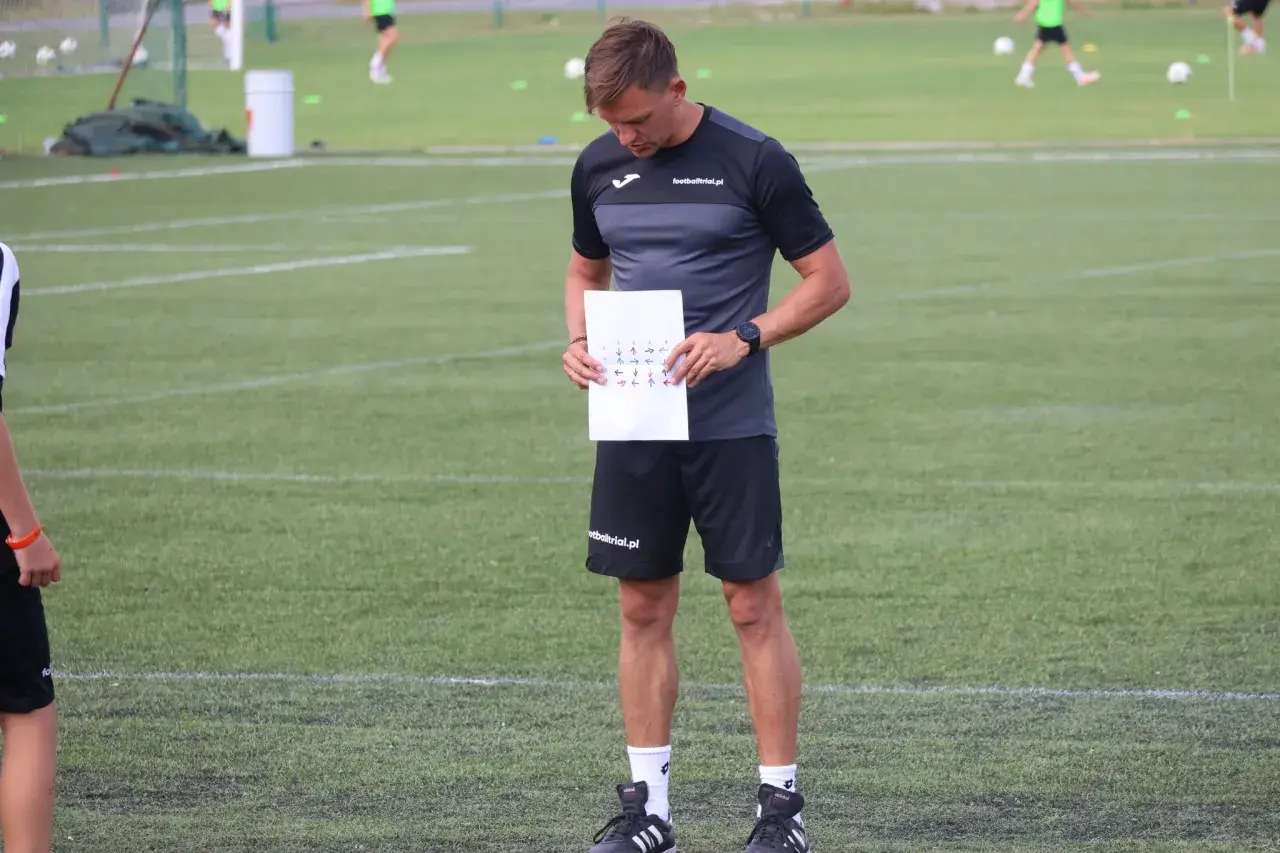 Trener analizuje schemat ruchów na boisku, przygotowując test matthiasa.