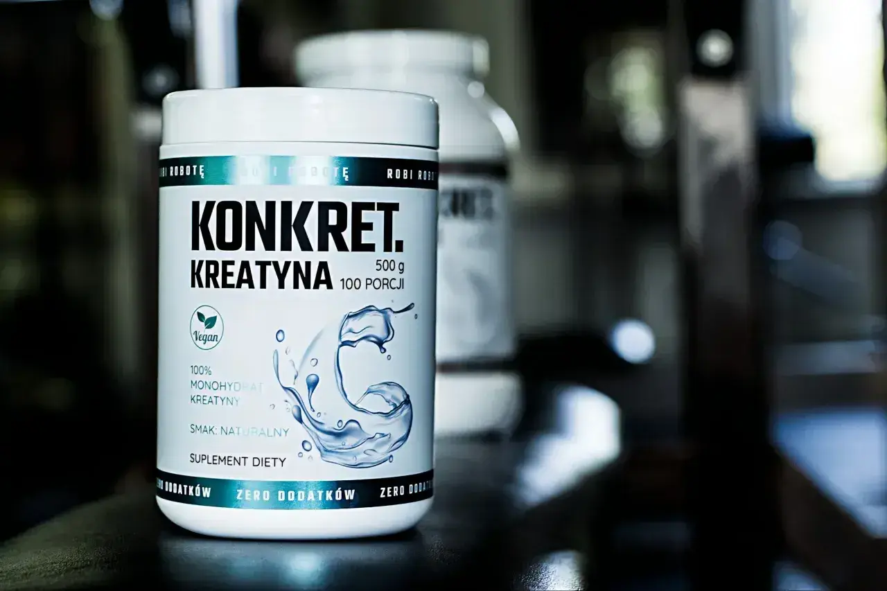 Biały słoik z napisem "KONKRET. KREATYNA" i grafiką wody. To suplement diety, jaka kreatyna dla Ciebie?