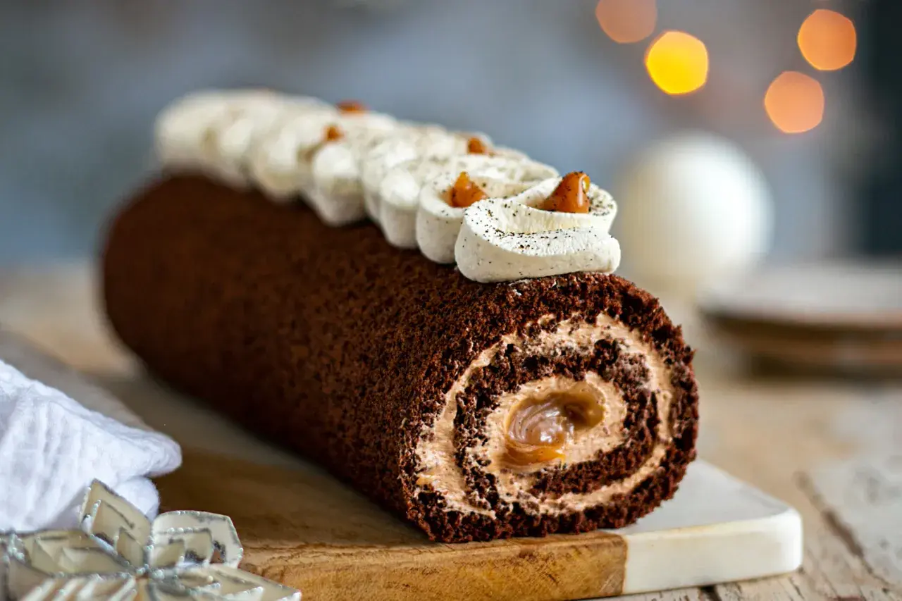 Une délicieuse buche chocolat au lait, roulée et garnie de crème onctueuse, prête à être dégustée.
