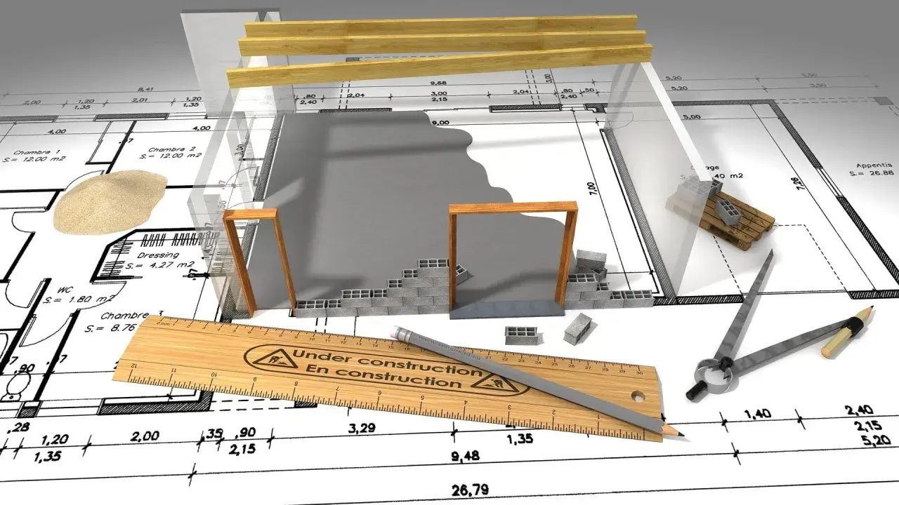 Plans de construction, outils et matériaux suggèrent un projet en cours, mais le panneau "En construction" et la règle indiquent que le permis de construire annulé a stoppé net les travaux.