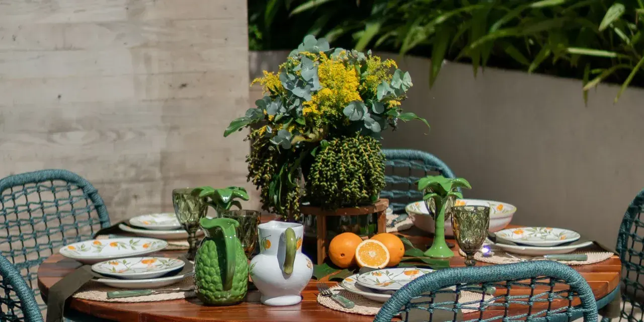 A vibrant tablescape with citrus-themed plates, green pitchers, and a lush floral arrangement. This modern everyday dining table decor evokes a fresh, summery feel.