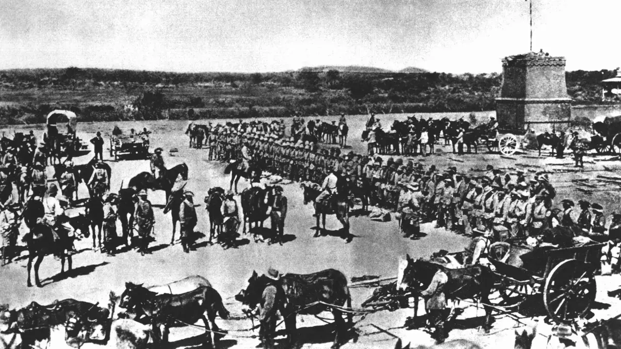Soldaten und Pferde versammeln sich vor einem Turm. Die Szene erinnert an die Schlacht am Waterberg, ein entscheidendes Ereignis in der Kolonialgeschichte.