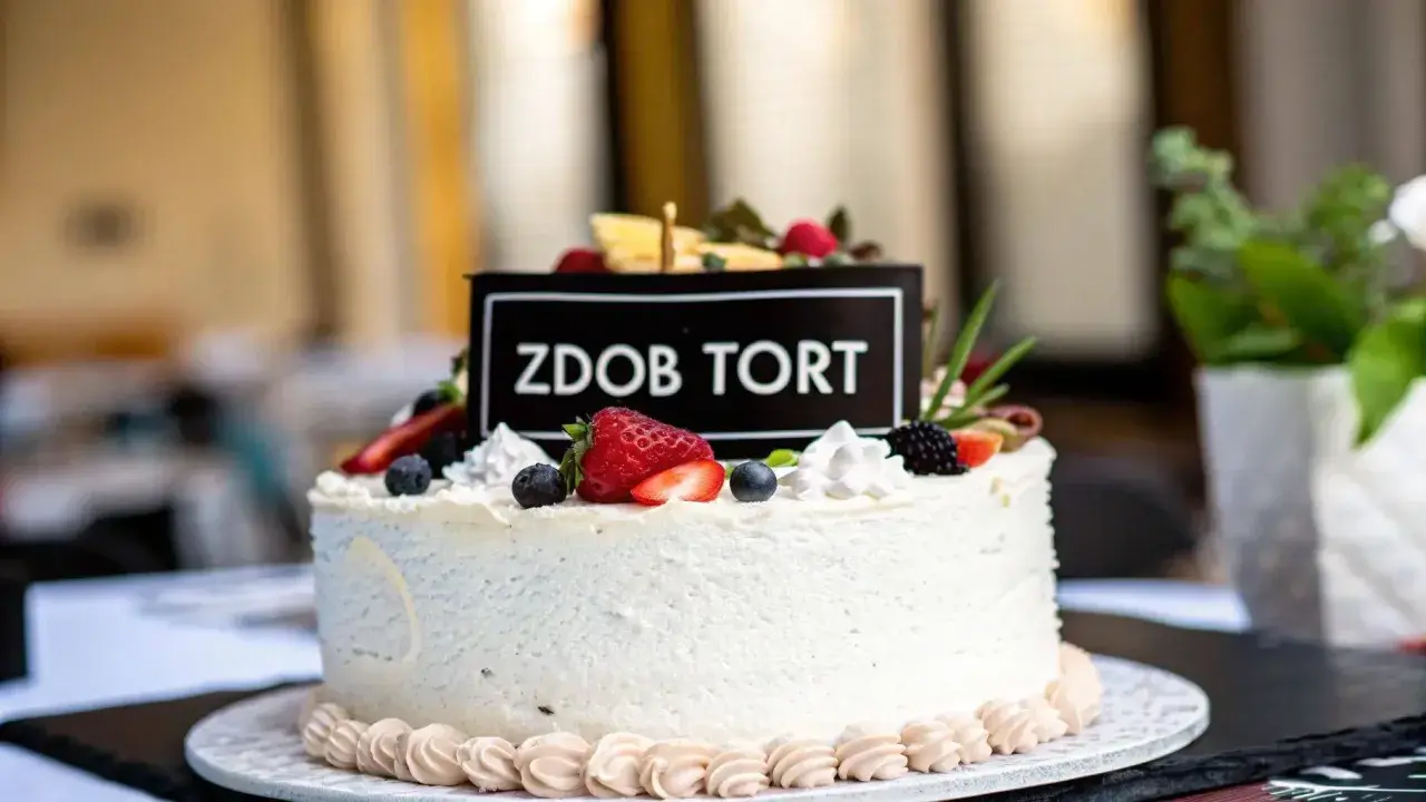 Elegancki tort dla 14 latki, ozdobiony świeżymi owocami i napisem "Zdob Tort". Idealny na wyjątkową okazję.
